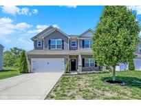 Charming two-story home with a well-manicured lawn and attached two-car garage at 4032 Stubbington Ln, Indianapolis, IN 46239