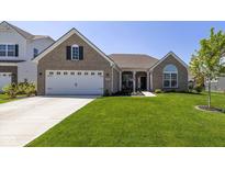 Inviting brick home with a well-manicured lawn, attached two-car garage and charming covered porch at 5375 Citadel Dr, Noblesville, IN 46062