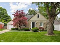 Charming stone home features a well-manicured lawn and a mature maple tree at 5439 Indianola Ave, Indianapolis, IN 46220