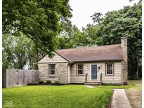 Charming single-story home featuring stone accents, a well-manicured lawn, and a cozy entryway at 6137 Evanston Ave, Indianapolis, IN 46220