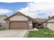 Charming single-story home featuring a well-manicured lawn, brick accents, and a two-car attached garage at 6503 E Walton Dr, Camby, IN 46113