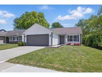 Charming single-story home with a well-manicured lawn, gray garage door, and white siding at 6613 Apollo Way, Indianapolis, IN 46278