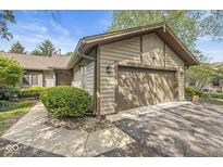 Charming exterior view features a two-car garage, attractive siding, and a well-manicured lawn at 8047 Van Ness Way, Indianapolis, IN 46240