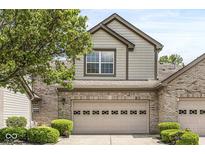 Charming home with a two-car garage, decorative door, beautiful brick accents, and landscaped front yard at 10143 Winslow Way, Fishers, IN 46037