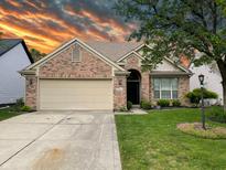 Charming single-story brick home featuring a two-car garage, manicured lawn, and beautiful landscaping at 10305 Lakeland Dr, Fishers, IN 46037