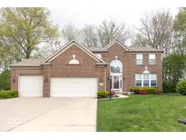Charming two-story brick home with attached three-car garage and well-manicured front lawn at 12253 Bedrock Ct, Fishers, IN 46037