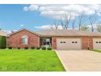 Charming brick home featuring a well-manicured lawn and an attached two-car garage at 217 Devonshire Ct, Anderson, IN 46013