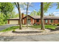 Charming brick home with manicured landscaping and inviting entrance, with a circular driveway at 2922 Amherst St, Indianapolis, IN 46268