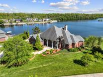 Beautiful waterfront property featuring a meticulously landscaped lawn and manicured garden beds at 3107 Waterfront Cir, Anderson, IN 46012