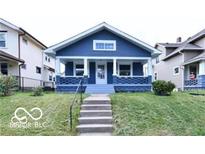 Charming blue craftsman-style home featuring a welcoming front porch and well-maintained lawn at 36 N Ewing St, Indianapolis, IN 46201