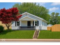 Charming single-story home with white siding, black shutters, green lawn, and a red maple tree in the front yard at 3720 W 16Th St, Indianapolis, IN 46222