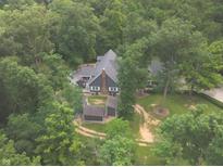 Expansive gray home surrounded by mature trees and lush greenery in a peaceful, wooded setting at 4363 E State Road 252, Franklin, IN 46131