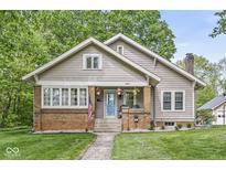 Charming home featuring a brick and siding facade, a blue door, and a welcoming front porch at 440 W Marion St, Danville, IN 46122