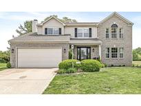 Charming two-story brick home featuring an attached two-car garage and a well-manicured front yard at 523 Torrey Ct, Avon, IN 46123
