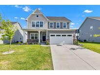 Charming two-story home with a well-maintained lawn, a two car garage, and a classic covered front porch at 6305 Norwich Dr, Brownsburg, IN 46112