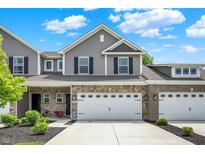 Beautiful townhome with a two-car garage, charming brick accents, and a well-maintained lawn at 6429 Yuma Ct, Whitestown, IN 46075