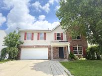 Two story home with brick and vinyl siding, red shutters, attached garage, and partial cloudy sky at 6903 Governors Pointe Blvd, Indianapolis, IN 46217