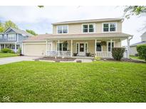Charming two-story home featuring a welcoming front porch, manicured lawn, and an attached garage at 7249 Tappan Dr, Indianapolis, IN 46268
