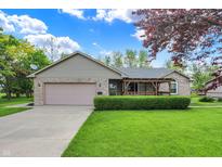 Charming brick ranch home featuring a lush front lawn, covered porch, and attached two-car garage at 7655 N Kitchen Rd, Mooresville, IN 46158