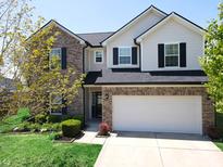 Two-story home featuring a brick and vinyl exterior, black shutters, well-maintained landscaping, and an attached two-car garage at 11155 Funny Cide Dr, Noblesville, IN 46060