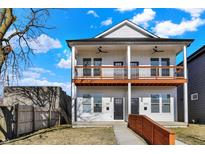 Charming two-story home with a welcoming front porch and a well-maintained lawn and beautiful blue sky at 2013 Yandes St, Indianapolis, IN 46202