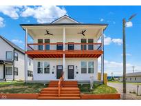 Charming two-story duplex with a vibrant orange staircase and a shared porch at 2013 Yandes St, Indianapolis, IN 46202