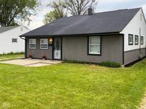 Charming one-story home featuring manicured lawn, gray siding, and black trim at 2435 Asbury St, Indianapolis, IN 46203