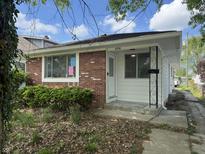 Charming single-story home featuring a brick facade and a well-maintained front yard at 4956 W 11Th St, Speedway, IN 46224