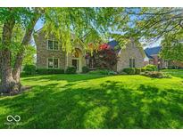 Charming two-story brick home with mature trees and lush green lawn at 5783 Coopers Hawk Dr, Carmel, IN 46033