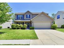 Charming two-story home featuring manicured lawn and a two-car garage at 5827 High Grass Ln, Indianapolis, IN 46235