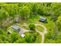 Stunning aerial view of a charming log cabin nestled on a beautiful lot surrounded by lush greenery and mature trees at 6968 S 300 W, Trafalgar, IN 46181