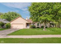 Charming single-story home featuring a brick facade, well-manicured lawn, and mature shade tree at 7606 Old Oakland Blvd E Dr, Indianapolis, IN 46236
