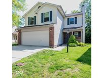Charming two-story home boasts a large front yard, two-car garage and updated siding and windows at 7611 Misty Meadow Dr, Indianapolis, IN 46217