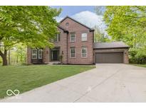 Charming brick home with a well-manicured lawn, mature trees, and attached two-car garage at 8300 Weaver Woods Pl, Fishers, IN 46038