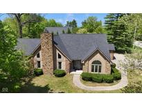 Beautiful home with stone chimney, black roof, and manicured front bushes at 10602 Fall Rd, Fishers, IN 46037