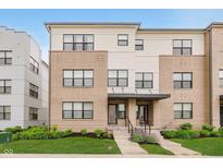 Modern townhouse with a combination brick and siding exterior and manicured lawn at 12990 Moultrie St, Carmel, IN 46032