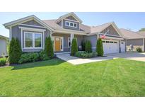Charming single-story home with a well-manicured lawn and welcoming yellow front door at 1472 Maple Ridge Ct, Columbus, IN 47201