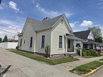 Charming home showcasing an inviting exterior with vinyl siding and a well-maintained gray roof on a sunny day at 152 1St W St, Shelbyville, IN 46176