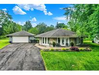 Charming ranch home with stone facade, well-manicured lawn and detached two-car garage at 169 Bayview Dr, Cicero, IN 46034