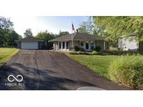 Charming home featuring a stone facade, flag pole, and a detached two car garage at 169 Bayview Dr, Cicero, IN 46034