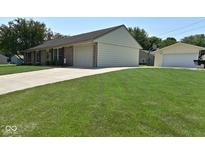Ranch-style home with a brick facade, attached garage, large green lawn and mature shade trees at 199 Three Notch Ln, Bargersville, IN 46106