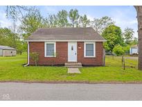 Charming brick home with a well-manicured lawn and a classic white front door at 2321 W 26Th St, Anderson, IN 46016