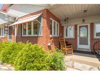 Charming covered front porch with brick accents and comfortable rocking chair seating area at 295 Maple Turn Rd, Martinsville, IN 46151