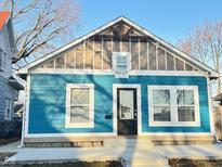 Charming bungalow with light blue wood siding, a front door, and white trim at 424 S Parker Ave, Indianapolis, IN 46201