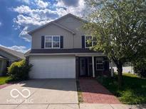 Two-story home features a two-car garage, tidy landscaping, and classic curb appeal at 4316 Village Trace Dr, Indianapolis, IN 46254