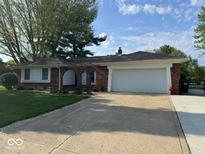 Charming brick ranch home with a two-car garage and well-manicured lawn at 4336 Bittersweet Ln, Greenwood, IN 46142