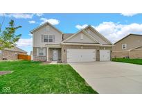 Charming two-story home featuring a well-manicured lawn, brick accents, and an attached two-car garage at 4763 W Tradwell Dr, New Palestine, IN 46163
