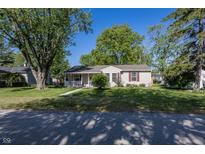 Charming single-story home with a well-manicured lawn and mature trees on a sunny day at 540 Hanley St, Plainfield, IN 46168