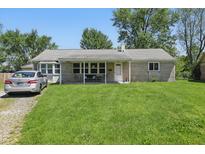Charming single-story home featuring a well-manicured lawn and covered front porch at 633 Park Dr, Greenwood, IN 46143