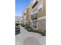 Beautiful exterior with stone accents, a small balcony, and a well-maintained walkway at 6665 Boxcar Pl, Indianapolis, IN 46220